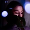 Concentrated young female in gloves and sweater with long eyelashes on closed eyes at dusk