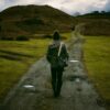 Person walking on a scenic countryside trail, embracing solitude and nature.