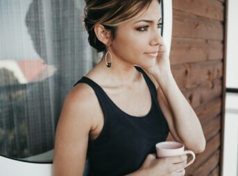 woman wearing black tank top holding mug
