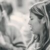 A black and white photo of a woman talking to another woman