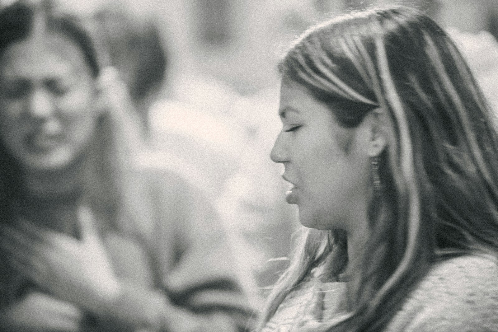 A black and white photo of a woman talking to another woman