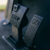 Close-up photograph of Go and Stop pedals in a vehicle, highlighting texture.