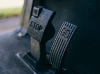 Close-up photograph of Go and Stop pedals in a vehicle, highlighting texture.