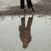 person in black pants and brown boots standing on gray concrete floor