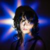 Young woman illuminated by a blue star-shaped light