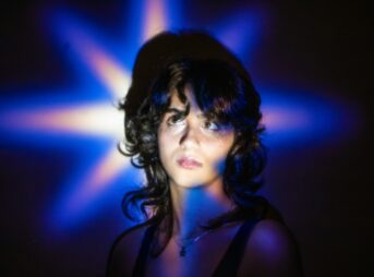 Young woman illuminated by a blue star-shaped light