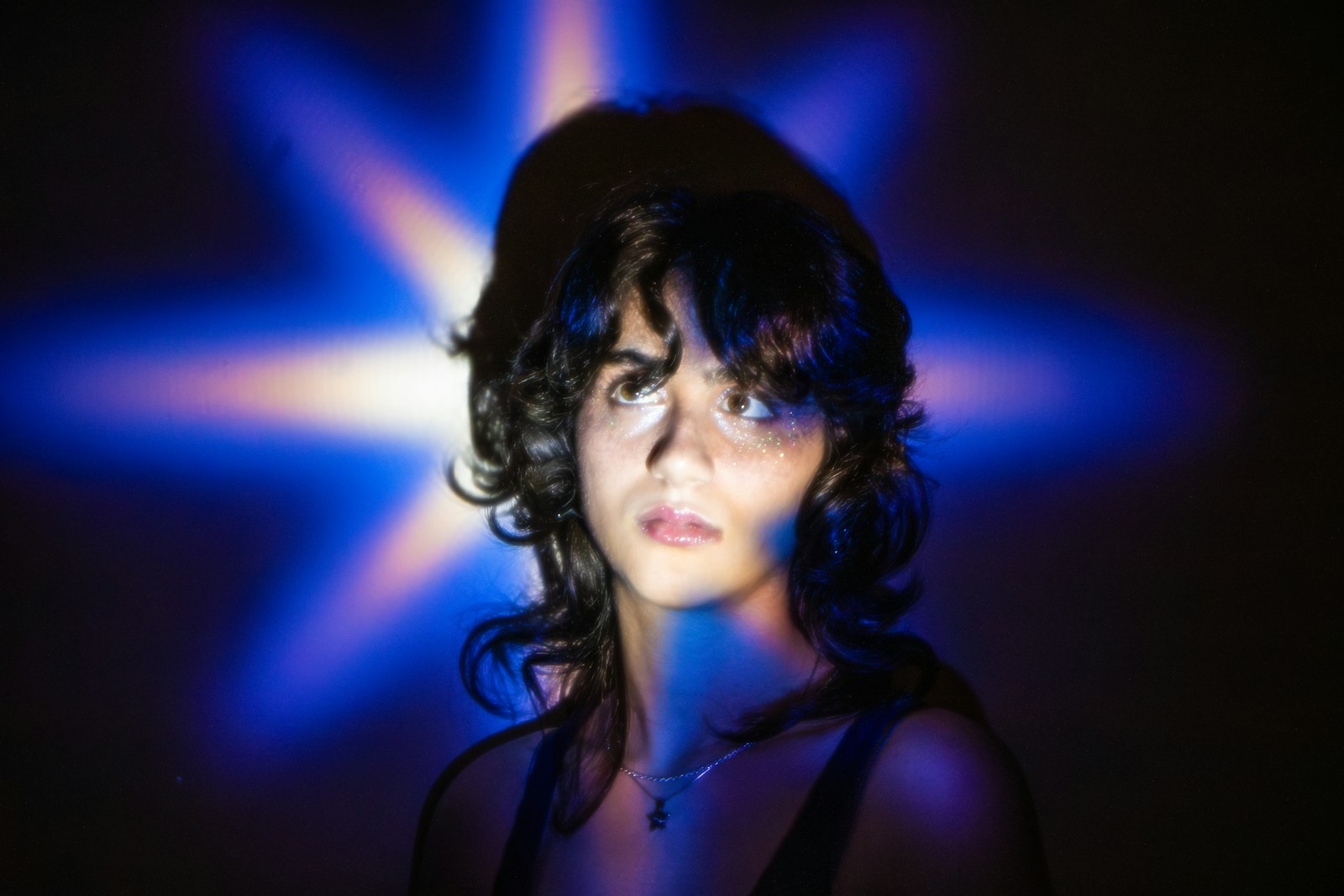 Young woman illuminated by a blue star-shaped light