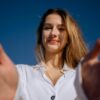 a woman in a white shirt holding out her hands