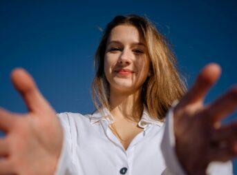 a woman in a white shirt holding out her hands
