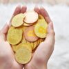 person holding gold round coins
