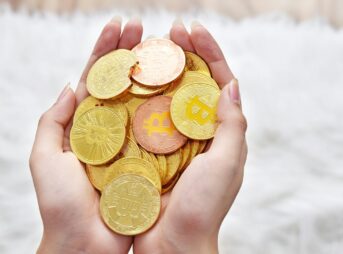person holding gold round coins