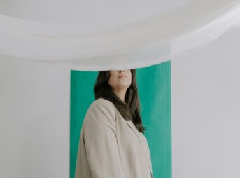 a woman standing in front of a green wall