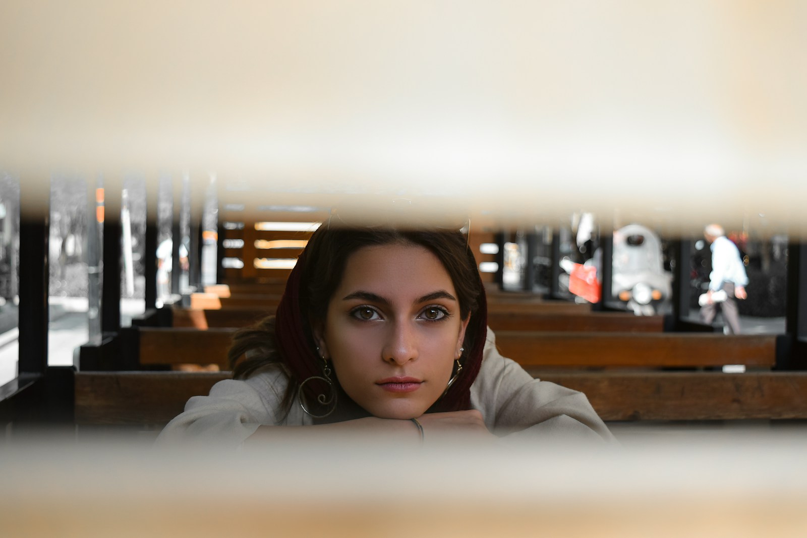 A woman sitting on a bench looking at the camera