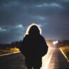 person in black jacket standing on road during daytime