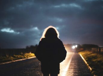 person in black jacket standing on road during daytime