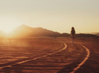 a person walking on a sandy beach