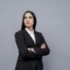 a woman in a business suit with her arms crossed