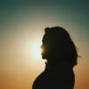 a silhouette of a person with the sun in the background
