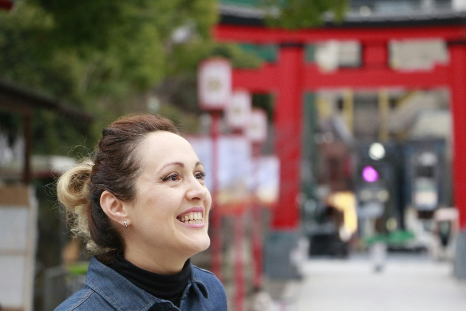 Woman smiling in front of a red shrine gate