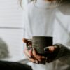 A woman holding a coffee cup in her hands