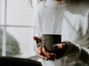 A woman holding a coffee cup in her hands